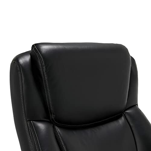 Close-up of black leather chair backrest