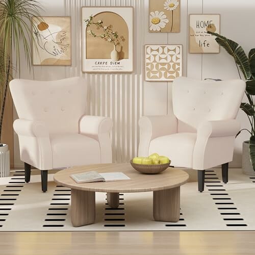 Two beige armchairs in a stylish living room setting with decorative wall art and a wooden coffee table.